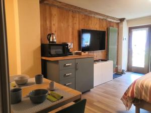 a living room with a television and a table with bowls at Petite Maison Gaspard in Valtournenche