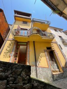 a yellow building with a balcony on the side of it at Bella casa nel cuore del Cilento in Montano Antilia