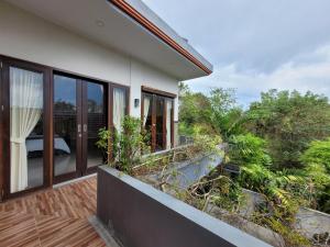 Una casa con balcón con vista al jardín. en Ramantika Sunset Bay, en Nusa Dua