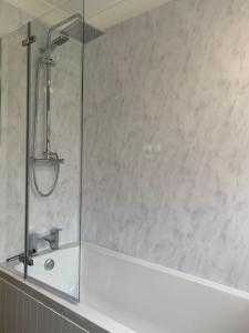 een badkamer met een douche met wastafel en spiegel bij Barley Break - Beach Cottage in Lessingham