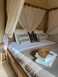 a bed with a canopy with pillows on it at Serengeti Safari Room in Sigean