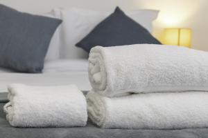 a pile of towels sitting on top of a bed at Upper Rock Brighton – Guest House in Brighton & Hove +29 photos