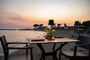 a table with two chairs and a lamp on the beach at Terra Park Phalaris in Novalja