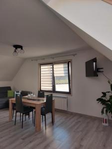 Zubrzyca DolnaZubrzycki Zakątek的一间有桌子、椅子和窗户的餐厅