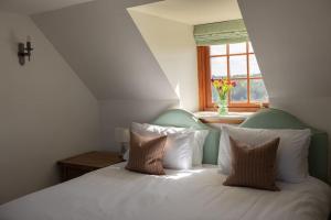 a bedroom with a white bed with pillows and a window at Balvraid Steading - Awesome views, near Dornoch in Dornoch