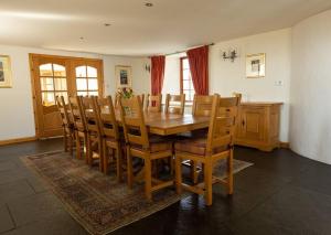 a dining room with a wooden table and chairs at Balvraid Steading - Awesome views, near Dornoch in Dornoch