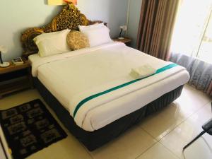 a large bed in a hotel room with a large white bedvisor at BGH LODGE in Gaborone +3 photos