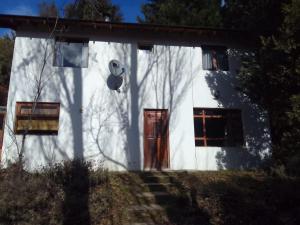 a white house with a red door and windows at Casa Blanca in San Carlos de Bariloche