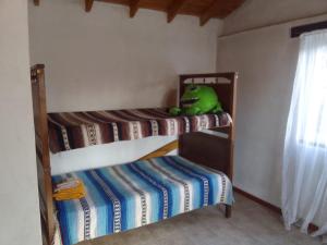 a bedroom with two bunk beds and a stuffed dinosaur at Casa Blanca in San Carlos de Bariloche