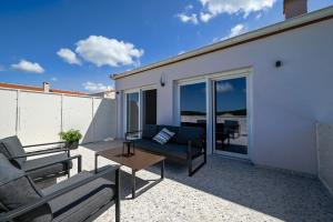 een patio met een bank en een tafel op een balkon bij Casa Ferata in Kanfanar