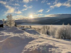 Ein schneebedeckter Hügel mit der Sonne im Hintergrund in der Unterkunft Solbergshyllan 2 in Åre