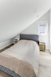 a bedroom with a large bed in a attic at Vila Naktižiedė in Šventoji