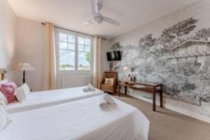 a bedroom with two white beds and a window at Hôtel Le Grain de Sable in Arès