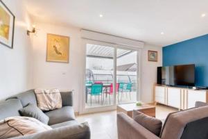 un salon avec un canapé et une télévision dans l'établissement Villa confortable à Ranville, piscine privée, à Ranville