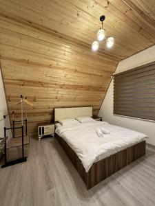 a bedroom with a large bed in a wooden ceiling at SILAND A Frame House in Gabala +13 photos