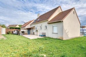 une maison blanche avec une cour gazonnée dans l'établissement Villa confortable à Ranville, piscine privée, à Ranville