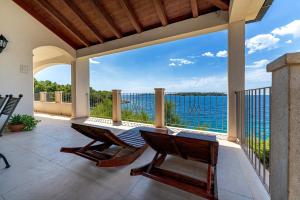 a patio with a table and chairs and the ocean at Villa Putto in Vela Luka