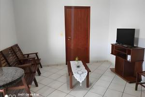 Una sala de estar con una mesa y un televisor. en AP. 06 DO CANTINHO DO SOSSEGO, en Dourados