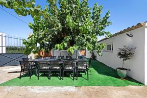 un tavolo e delle sedie sotto un albero di Cal Peret Miquelet a San Martín Sarroca