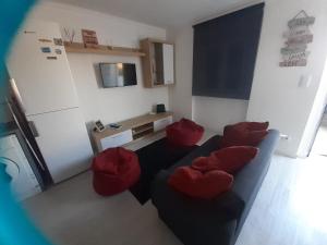 a living room with red pillows on a couch at Lourisol in Lourinhã