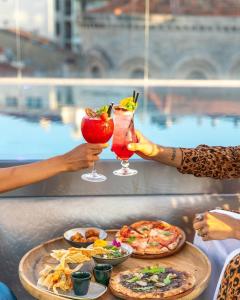 a group of people holding cocktails and food on a table at Five Seas by Inwood Hotels in Cannes