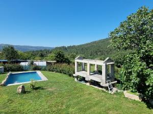 a garden with a bench next to a swimming pool at O POMAR VELLO in Pontevedra