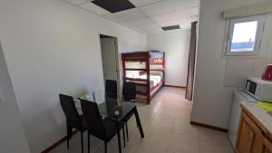 a room with a table and chairs and a bunk bed at Tres Arroyos Suite in Tres Arroyos
