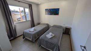 a hospital room with two beds and a window at Tres Arroyos Suite in Tres Arroyos