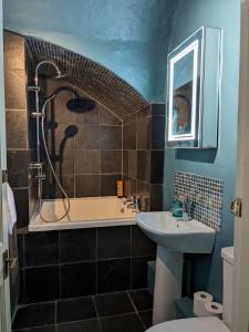 a bathroom with a tub and a sink and a shower at Two Bedroom flat in Caledonia Place in Bristol +25 photos