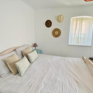 una camera da letto con un letto bianco con cuscini e una finestra di Blue Cottage a Şpring