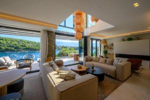 una sala de estar con un sofá y una mesa en Villa Ivy - an award winning beachfront villa on the island of Brac near Split, en Selca