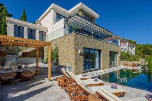 una casa con piscina y patio en Villa Ivy - an award winning beachfront villa on the island of Brac near Split, en Selca
