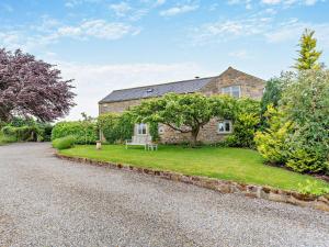 a stone house with a green lawn in front of it at 4 Bed in Masham 64329 in Grewelthorpe