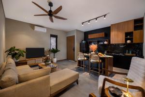 a living room with a ceiling fan and a kitchen at Canggu Bagus Suites in Canggu