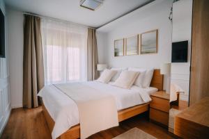 a bedroom with a white bed and a window at Villa Vukov Breg in Bogdanovec