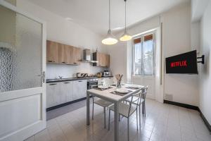 a kitchen with a table and chairs in a room at FERRARI - Stazione e centro città in Modena