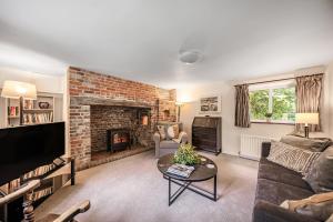a living room with a couch and a fireplace at Chapel Cottage in Winterborne Kingston