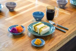 a wooden table with plates of food and a cup of coffee at Nikko Holiday Home Sumica in Nikko
