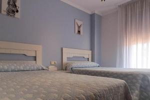 una camera da letto con due letti e una finestra di Luma, apartamento con terraza a Cambados