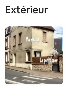 a building with a sign on the side of a street at Agréable maison de ville in LʼAigle