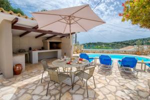 a patio with a table and chairs and a pool at Loggos Seaview Cottage with Private Pool by Konnect in Longos