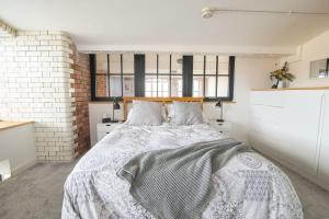 a bedroom with a bed and a brick wall at The Robinson Building in Bristol