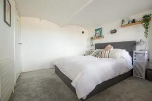 a bedroom with a large bed and a white wall at The Robinson Building in Bristol +6 photos