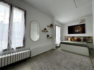a white room with a bed and a mirror at Maison proche stade de France in Aubervilliers