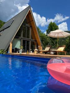 a house with a swimming pool and an umbrella at Hygge Cabana in Malaia