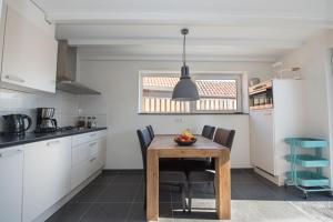 a kitchen with a wooden table and chairs in it at Holiday Home D'arke in Westkapelle