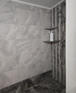a bathroom with a shower with a stone wall at Cozy City Apartment - sleeps 2 in Rhodes Town +13 photos