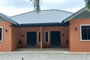 a house with black doors and a palm tree at Homestay73 - Parit Raja in Parit Raja