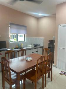 a kitchen with a wooden table and chairs in a room at Homestay73 - Parit Raja in Parit Raja +4 photos