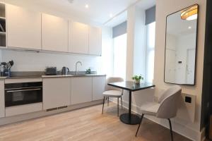 Una cocina con gabinetes blancos y una mesa y sillas. en Alliance House Studio - Hopewell, en Bristol